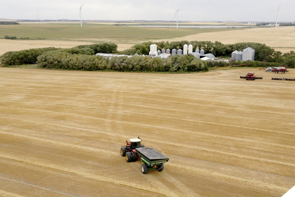 tractor driving in field towards farm