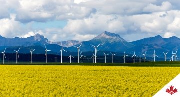 wind turbines in field near mountains