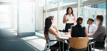 Femme d'affaires dirigeant une réunion dans un bureau en verre