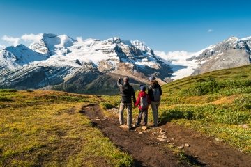 Famille avec un enfant regardant le mont Athabasca et le glacier Athabasca au col Wilcox, dans les Rocheuses canadiennes, parc national Jasper, Alberta, Canada.