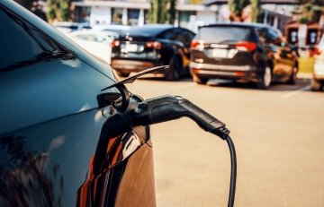 Une voiture électrique en cours de recharge dans un parking. 