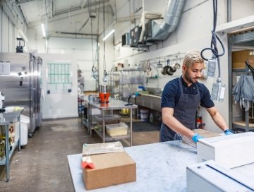 Chocolatier indien travaillant dans une chocolaterie. Il est vêtu d’un uniforme de travail. Intérieur d’une grande cuisine de la chocolaterie pendant la journée, à Toronto, au Canada.