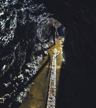 Silhouette d'un mineur d'or dans le puits étroit d'une mine d'or.