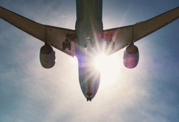 Avion de passagers rétroéclairé par le soleil de l’après-midi en préparation pour l’atterrissage.
