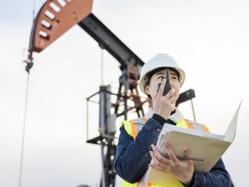 Travailleuse pétrolière sur un site d’extraction, avec talkie-walkie, Saskatchewan, Canada.
